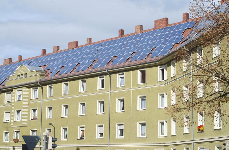 Grönt lägenhetshus med solceller på taket
