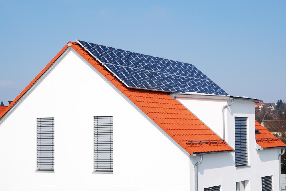 Villa med tegeltak som har solceller på taket